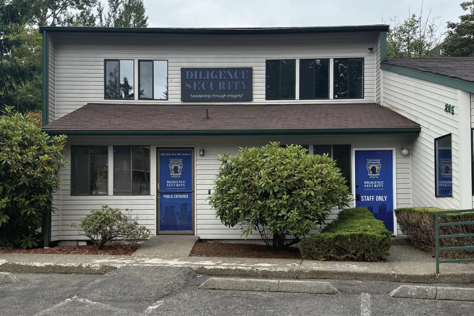 Office building exterior with installed sign, blue door wraps, and printed window graphics