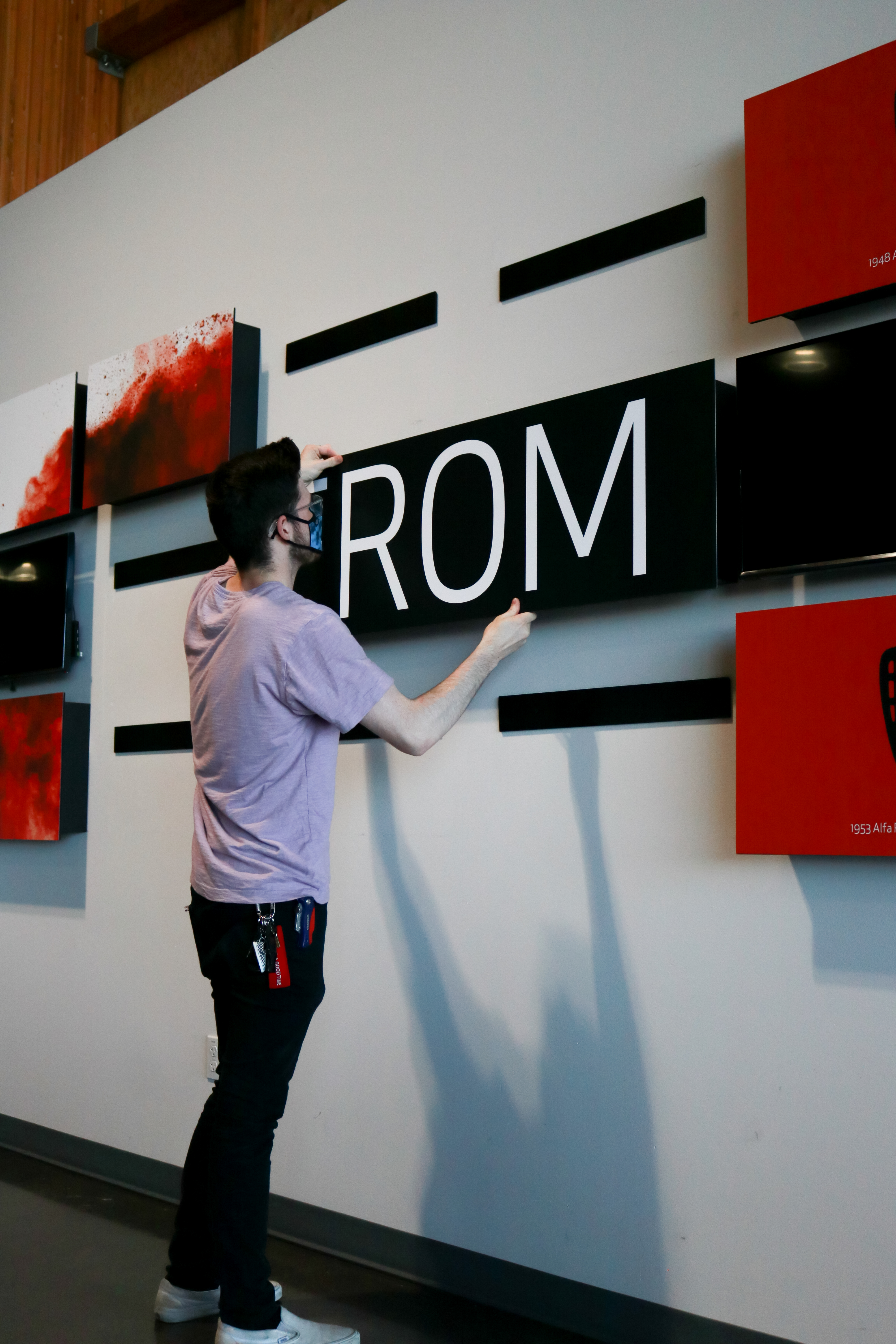 Installer applying large dimensional lettering to a dealership showroom wall