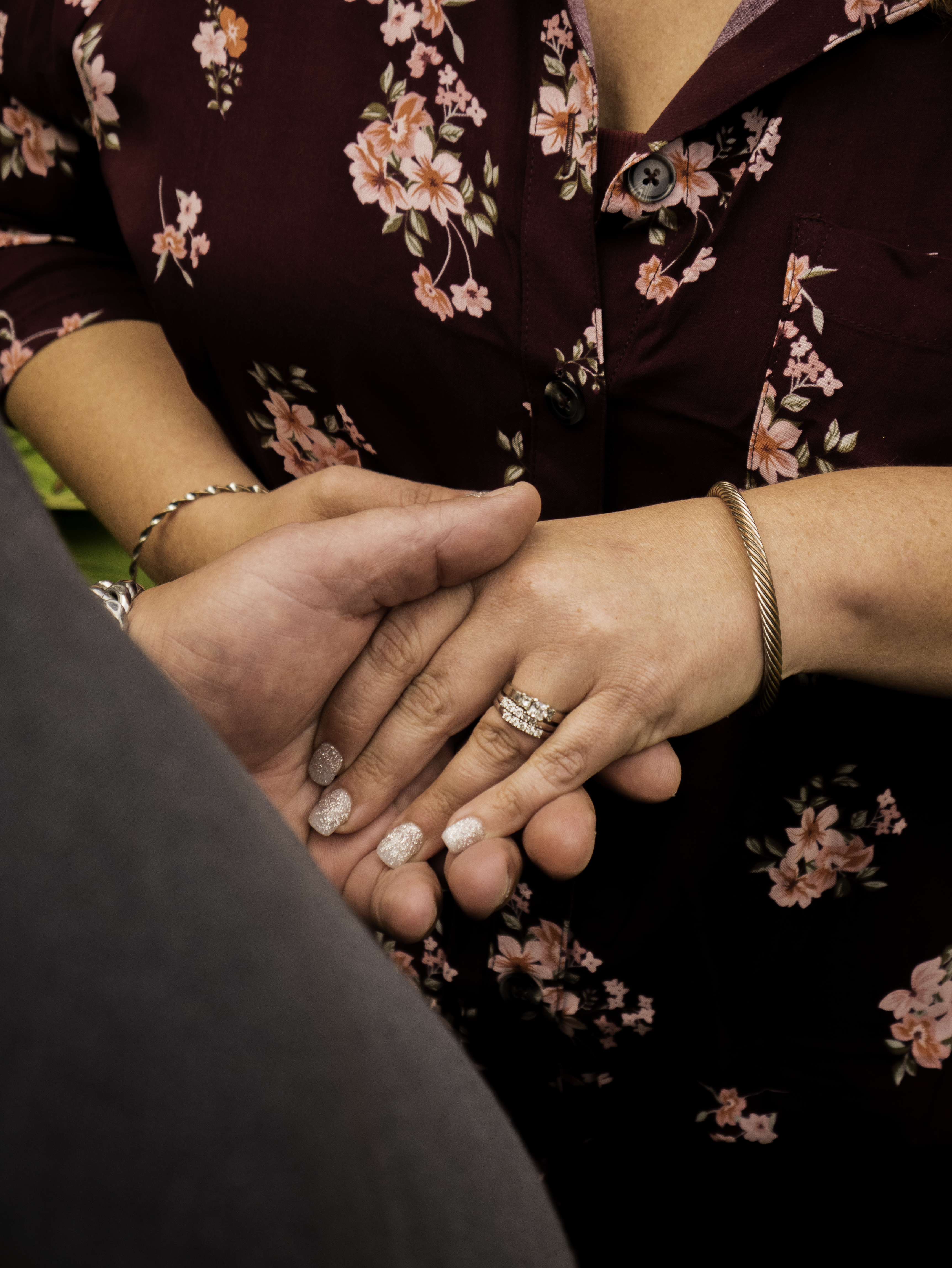 Close-up of a couple's hands and wedding rings resting together