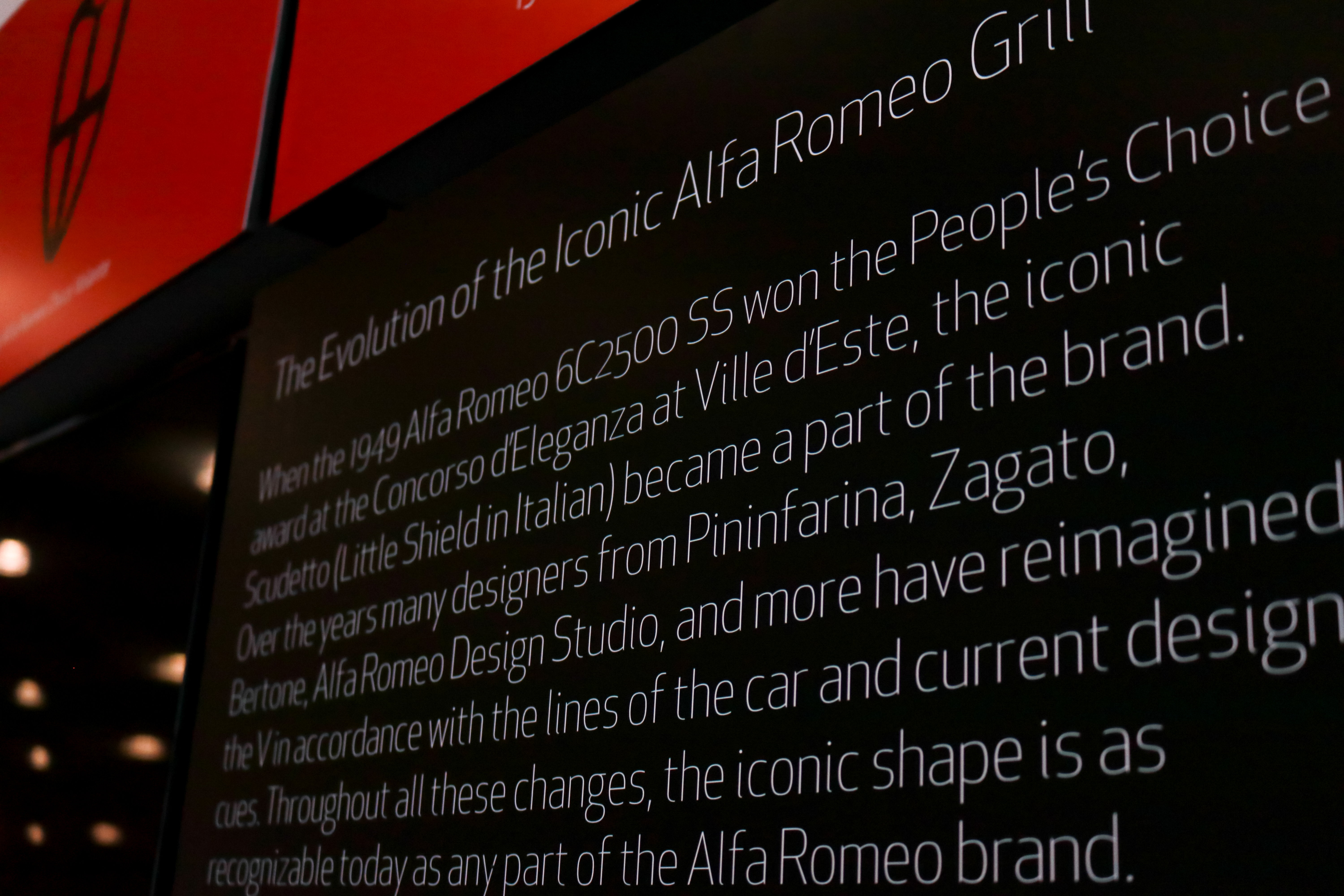 Printed showroom panel telling the history of the Alfa Romeo grille