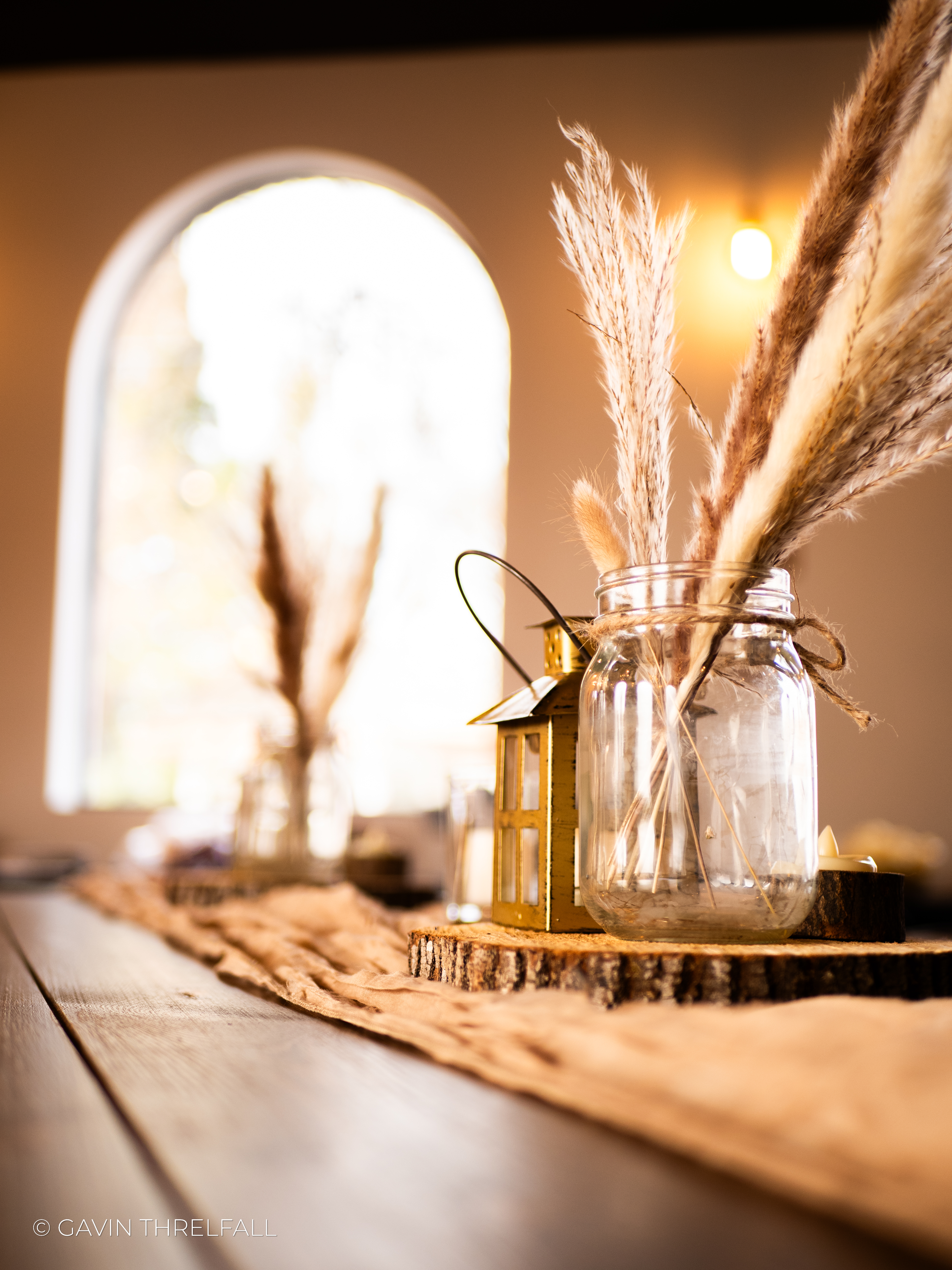 Pampas grass in a mason jar on a rustic wooden table