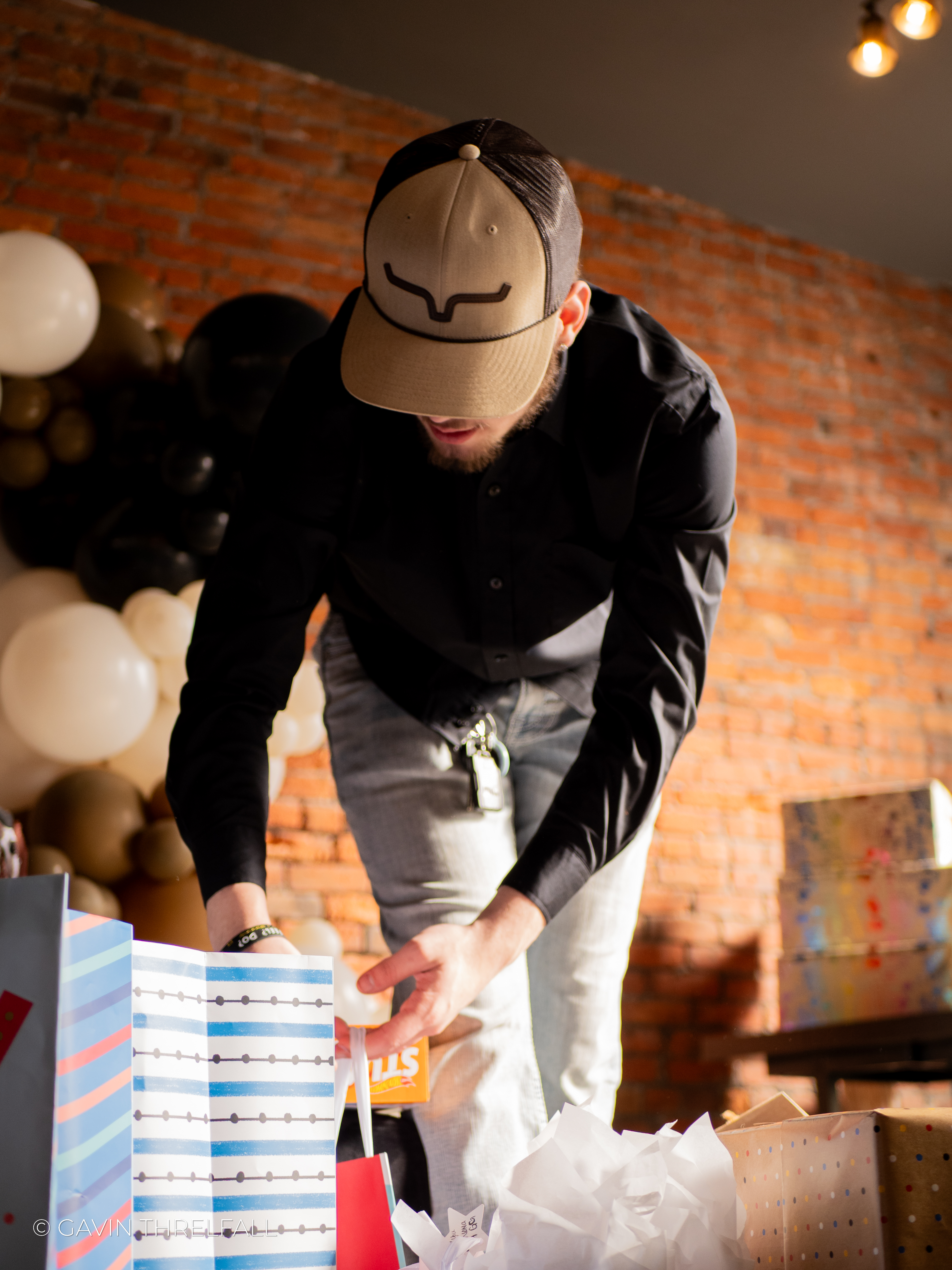 Man arranging gift bags on a table at a birthday celebration