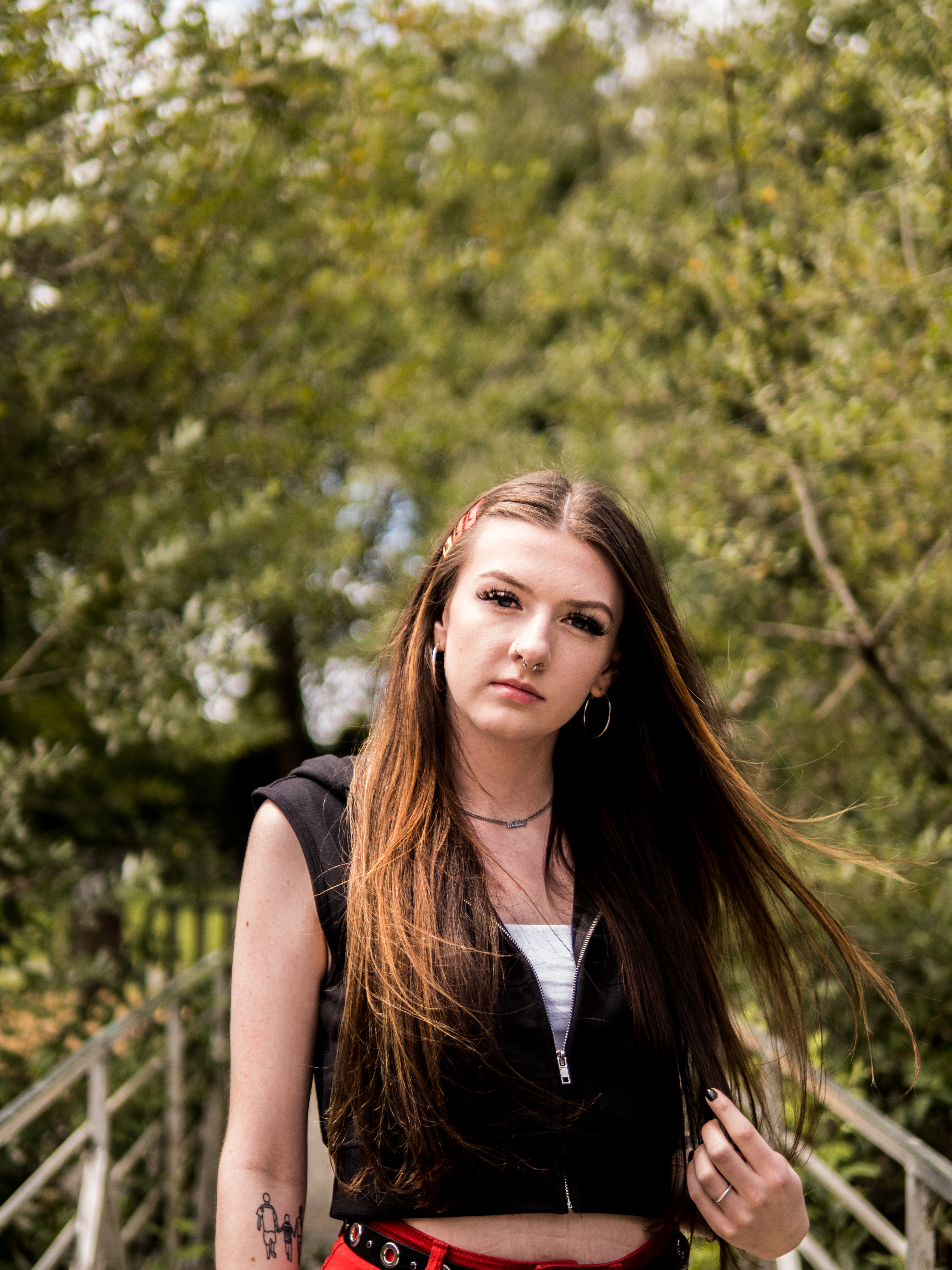 Senior portrait of a young woman with long hair blowing beside a river