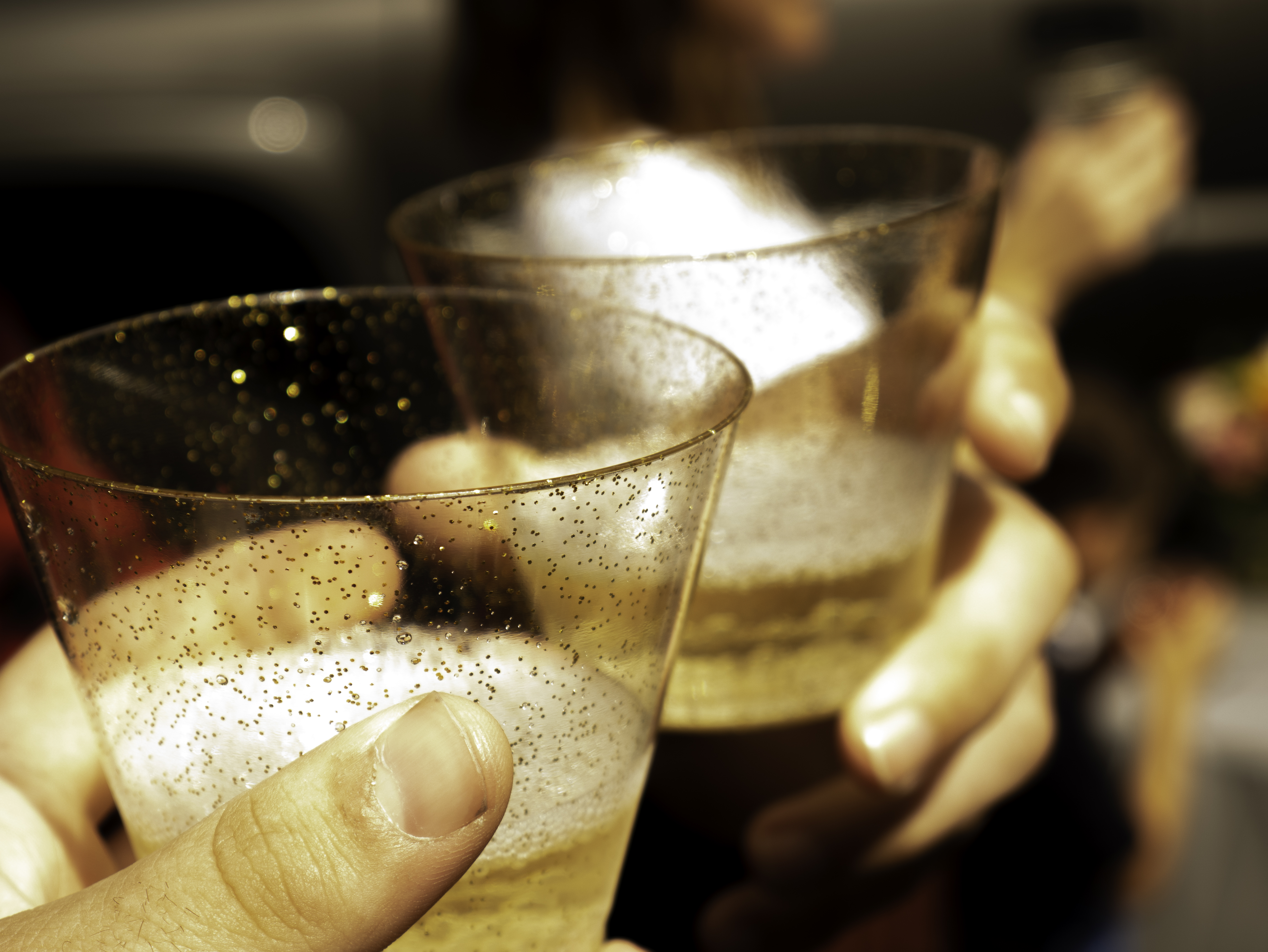 Glasses raised in a champagne toast at a wedding reception