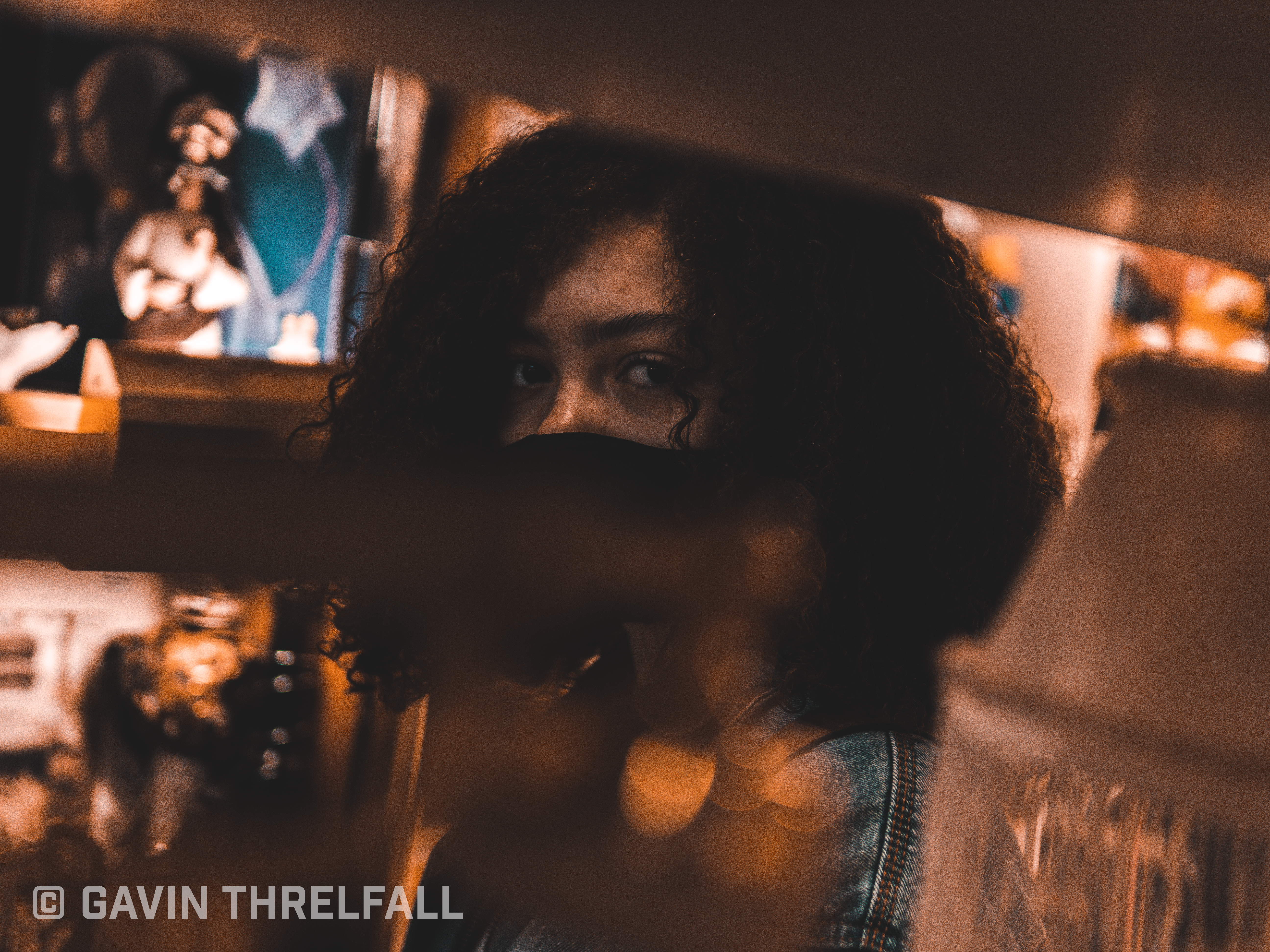 Portrait of a model seen through warm storefront window reflections