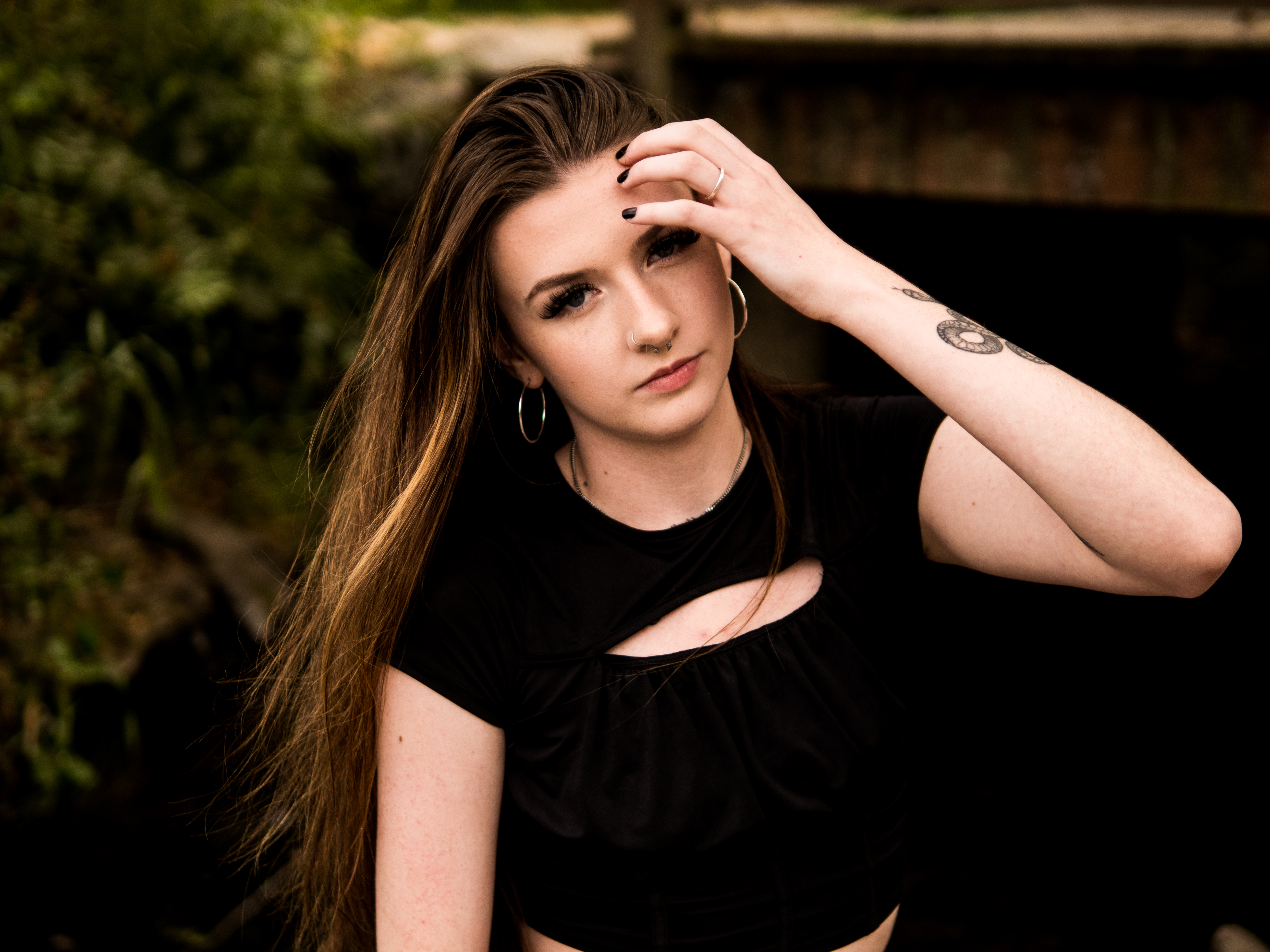 Senior portrait lit dramatically against a dark barn doorway